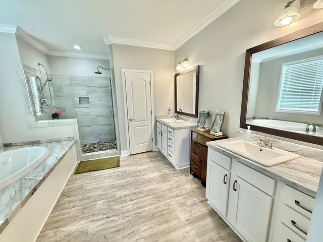 a spacious bathroom with a tub sink and mirror