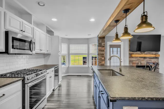 a kitchen with stainless steel appliances granite countertop a stove and a sink