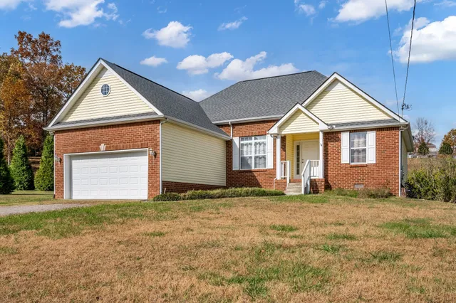 a view of a house with a yard and garage