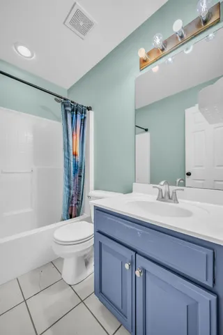 a bathroom with a sink a toilet a mirror a bathtub and shower