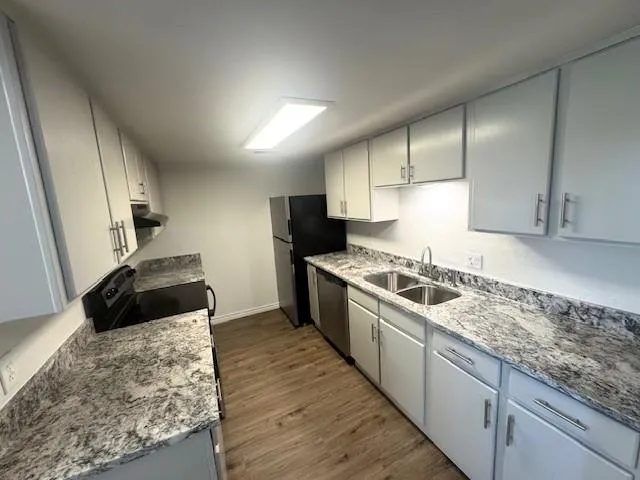 a large kitchen with a stove and a sink