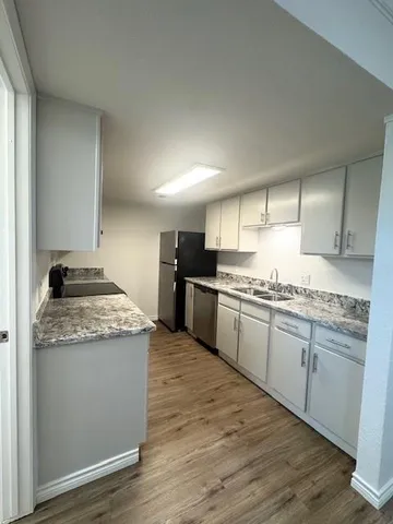 a kitchen with granite countertop stainless steel appliances and white cabinets