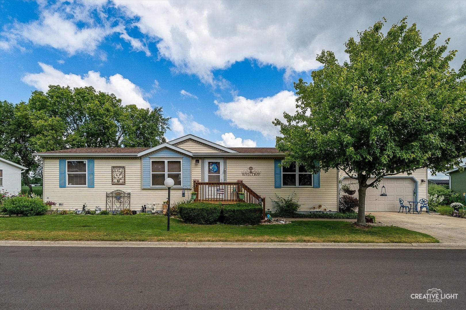 a front view of a house with a yard and trees