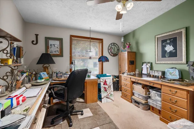 a view of a workspace with furniture and a window