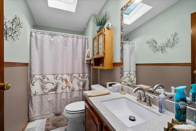 a bathroom with a sink a toilet and a mirror