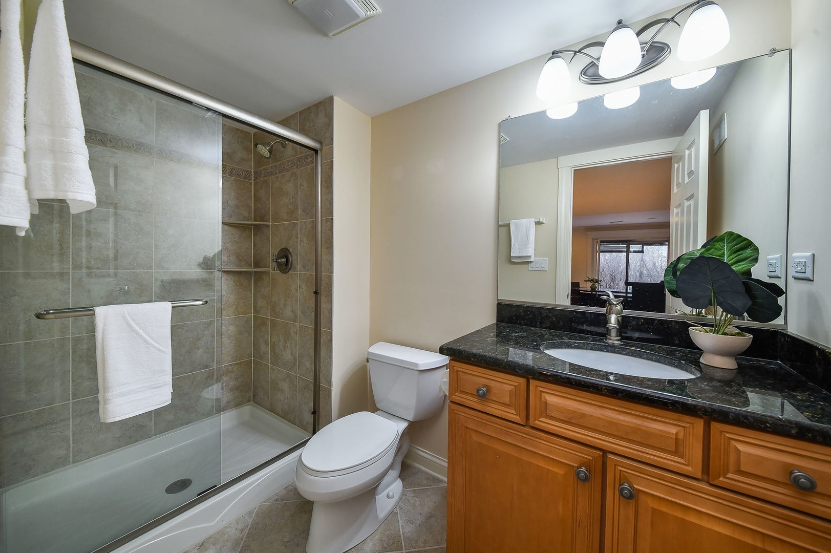 1811 Rizzi Lane, Unit 1811 Bartlett, IL 60103 - Photo 25 of 29 a bathroom with a granite countertop sink a toilet and shower