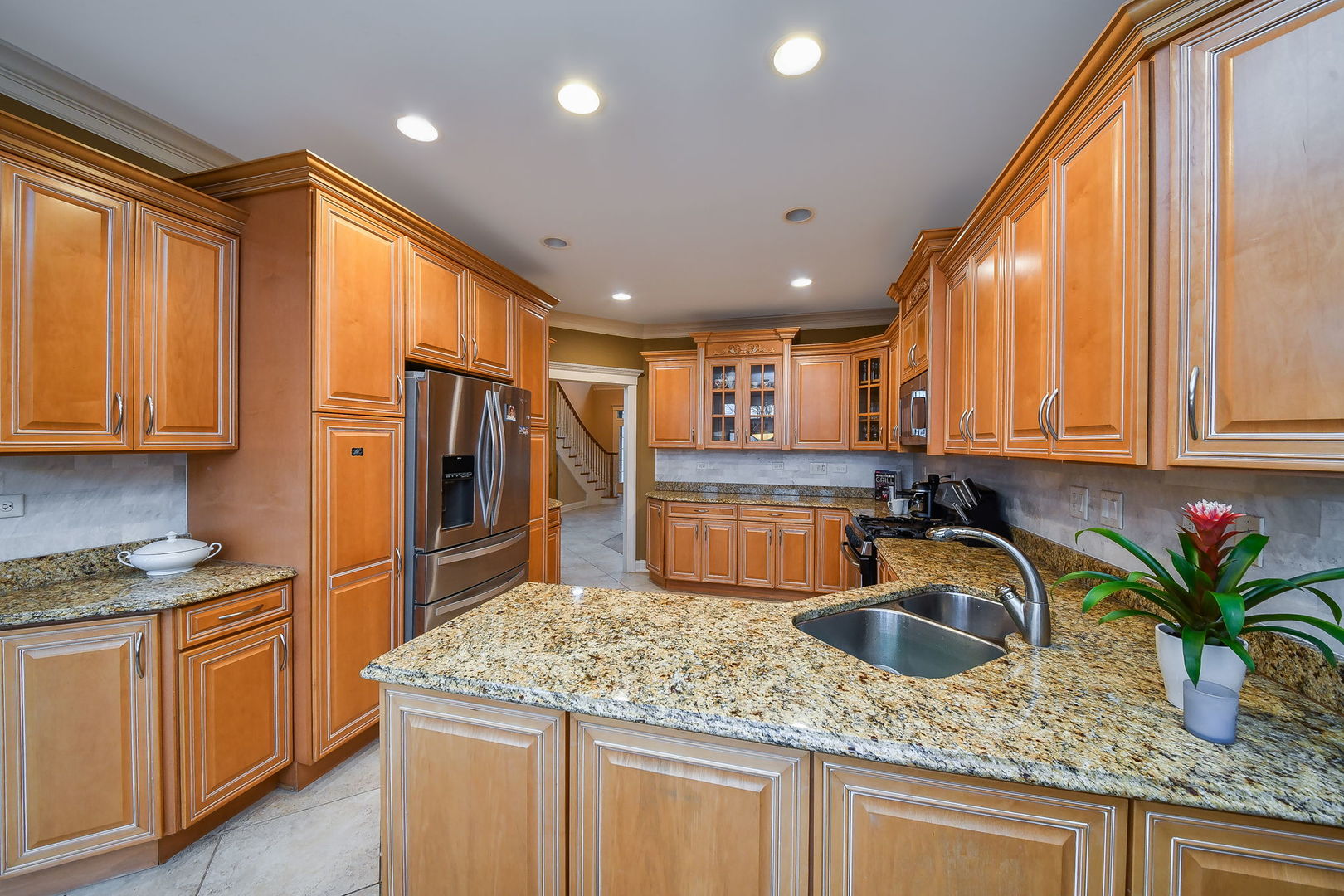 1811 Rizzi Lane, Unit 1811 Bartlett, IL 60103 - Photo 8 of 29 a kitchen with stainless steel appliances granite countertop sink stove refrigerator and cabinets