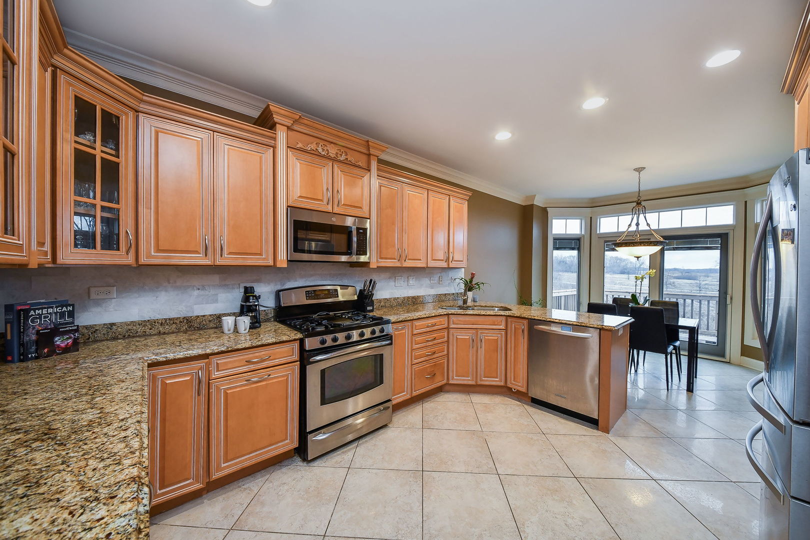1811 Rizzi Lane, Unit 1811 Bartlett, IL 60103 - Photo 9 of 29 a kitchen with stainless steel appliances granite countertop a stove top oven a sink a counter top space cabinets and living room view