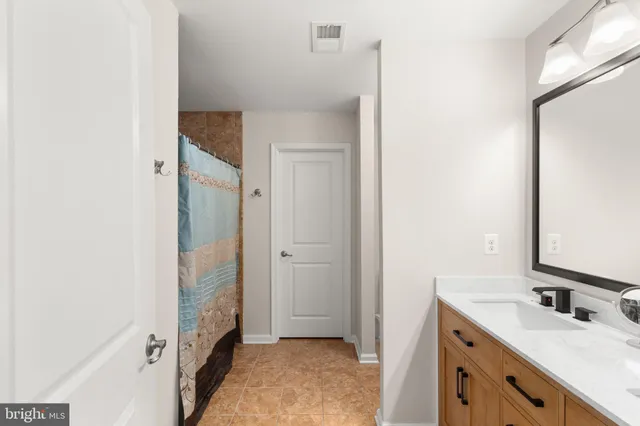 a bathroom with double vanity and a mirror