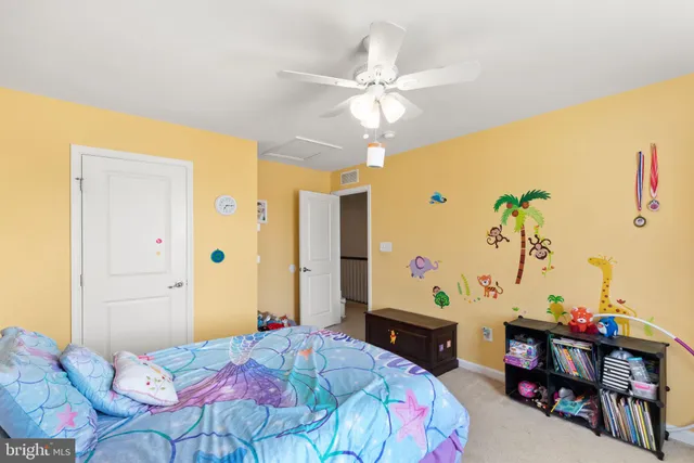 a bedroom with a bed a desk and chair with window