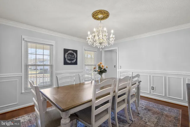 a view of a dining room with furniture and chandelier