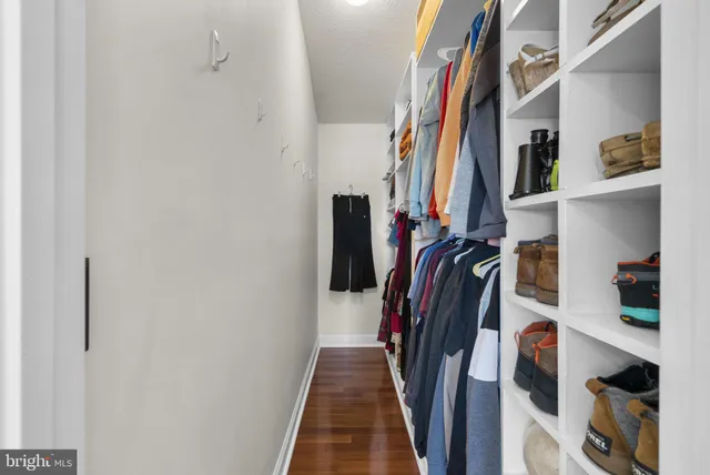 a view of walk in closet with clothes and shoes
