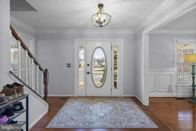 a view of a hallway with entryway wooden floor and front door