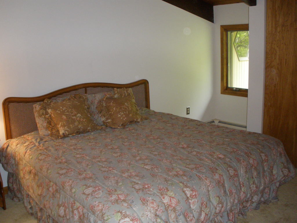 5 Butler Road Stockbridge, MA 01262 - Photo 21 of 22 a large bed sitting in a bedroom next to a window