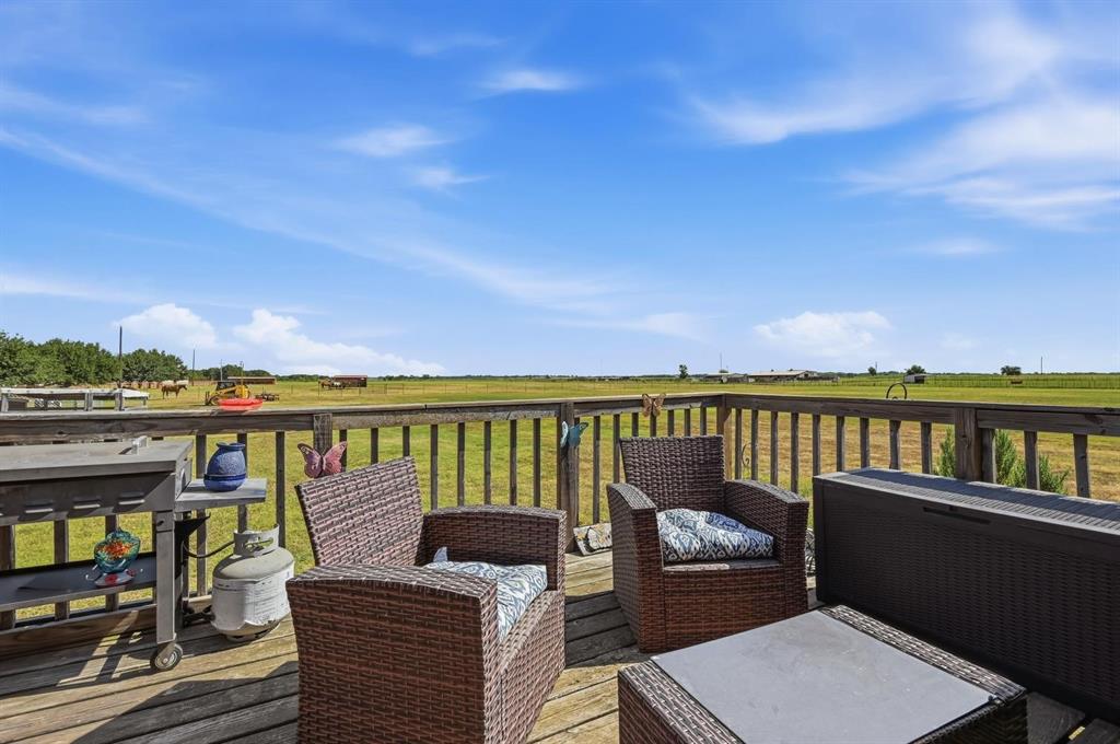 1802 Batey Road Collinsville, TX 76233 - Photo 26 of 33 Expansive wood-finish deck with wood railings, overlooking open green fields