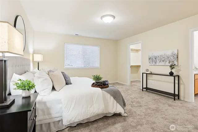 a bedroom with a bed table chair and a window