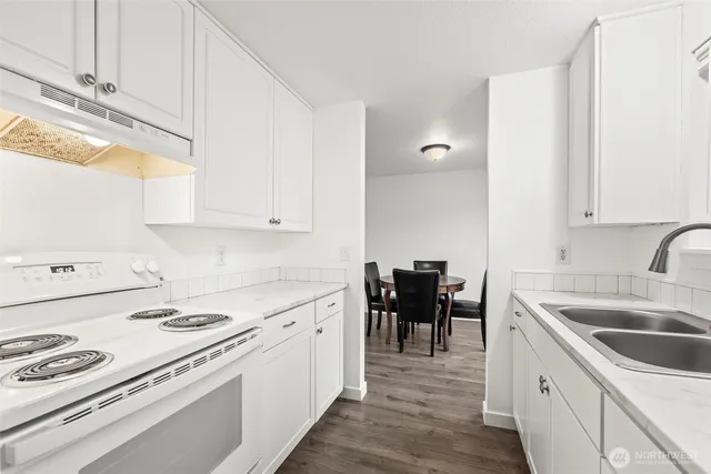 a kitchen that has a sink and a stove in it