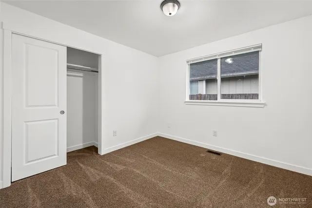 an empty room with windows and closet