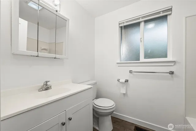 a bathroom with a sink a toilet and vanity