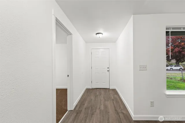 a view of a hallway with wooden floor