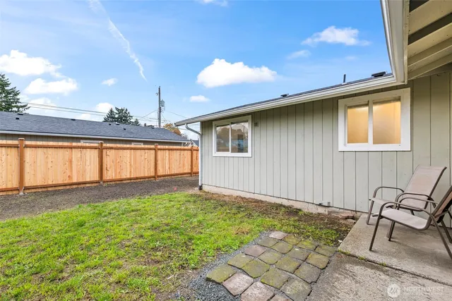 a view of a house with backyard and sitting area
