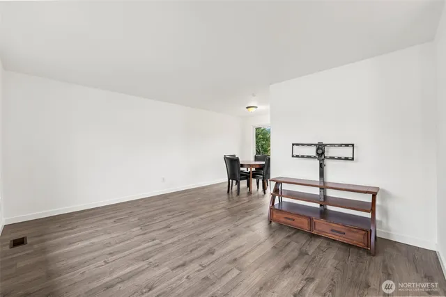 a view of a room with wooden floor and furniture