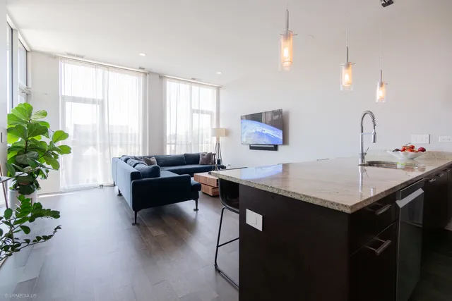 a kitchen with a table chairs sink and wooden floor