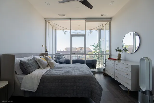 a bedroom with bed and a large window