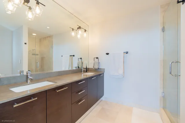 a bathroom with a granite countertop sink a large mirror and shower