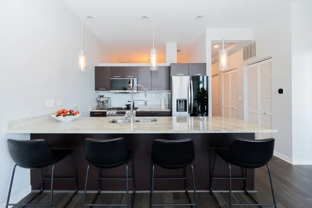 a kitchen with a sink and chairs