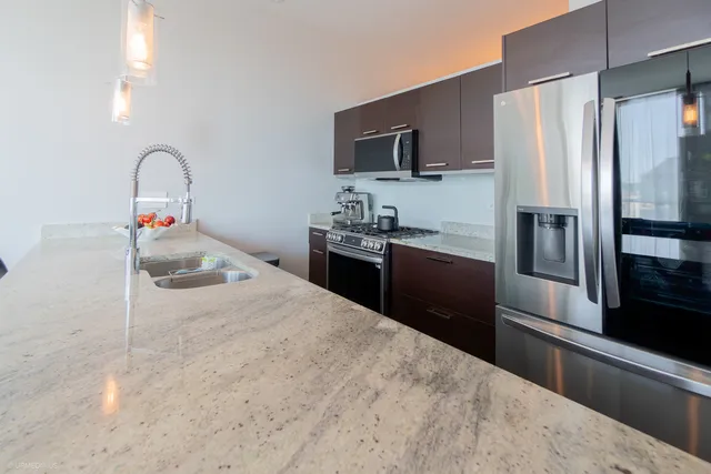 a kitchen with stainless steel appliances granite countertop a refrigerator and a sink