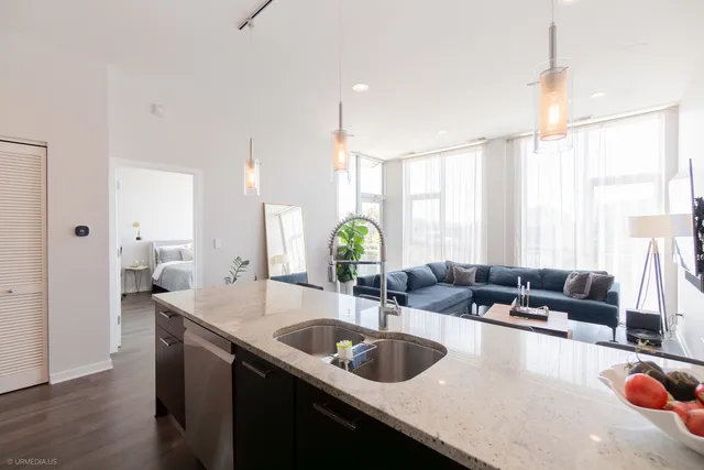 a kitchen with granite countertop a sink a counter top space and living room view