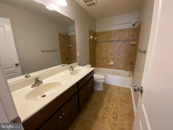 an empty room with windows and ceiling fan