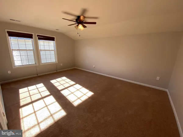 an empty room with a ceiling fan and a window
