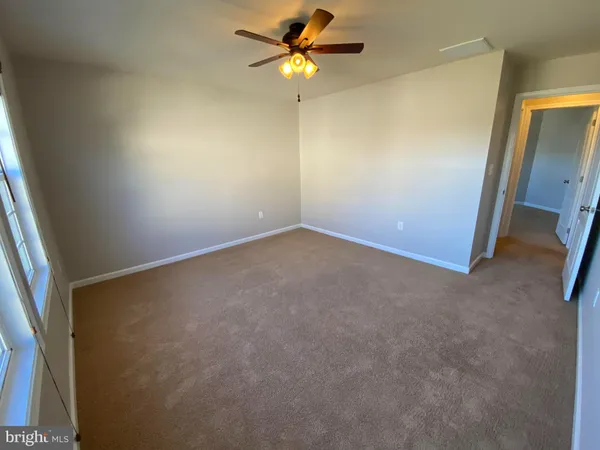 an empty room with a window and a fan