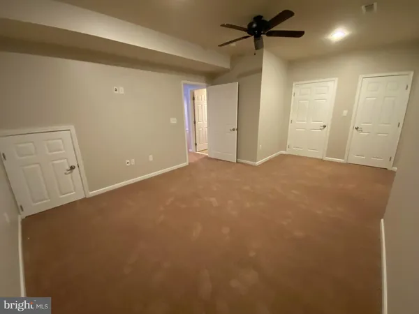 an empty room with a ceiling fan and window