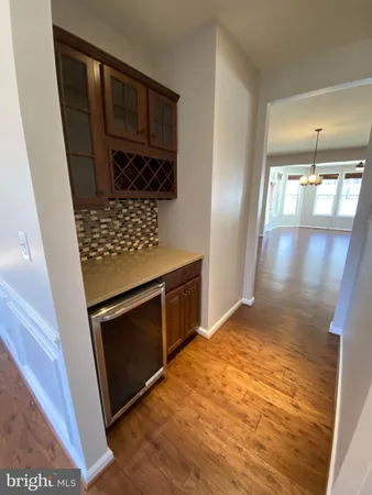 a large kitchen with a center island wooden floor and stainless steel appliances