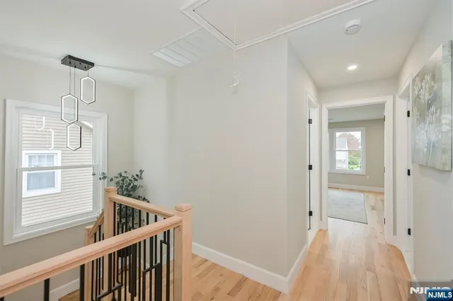 a view of a hallway with a window and wooden floor