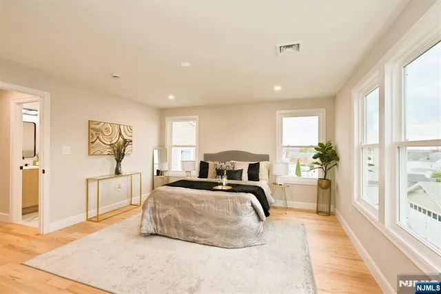 a bedroom with furniture and a large window