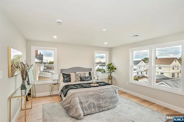 a bedroom with a large bed and a flat tv screen on the dresser