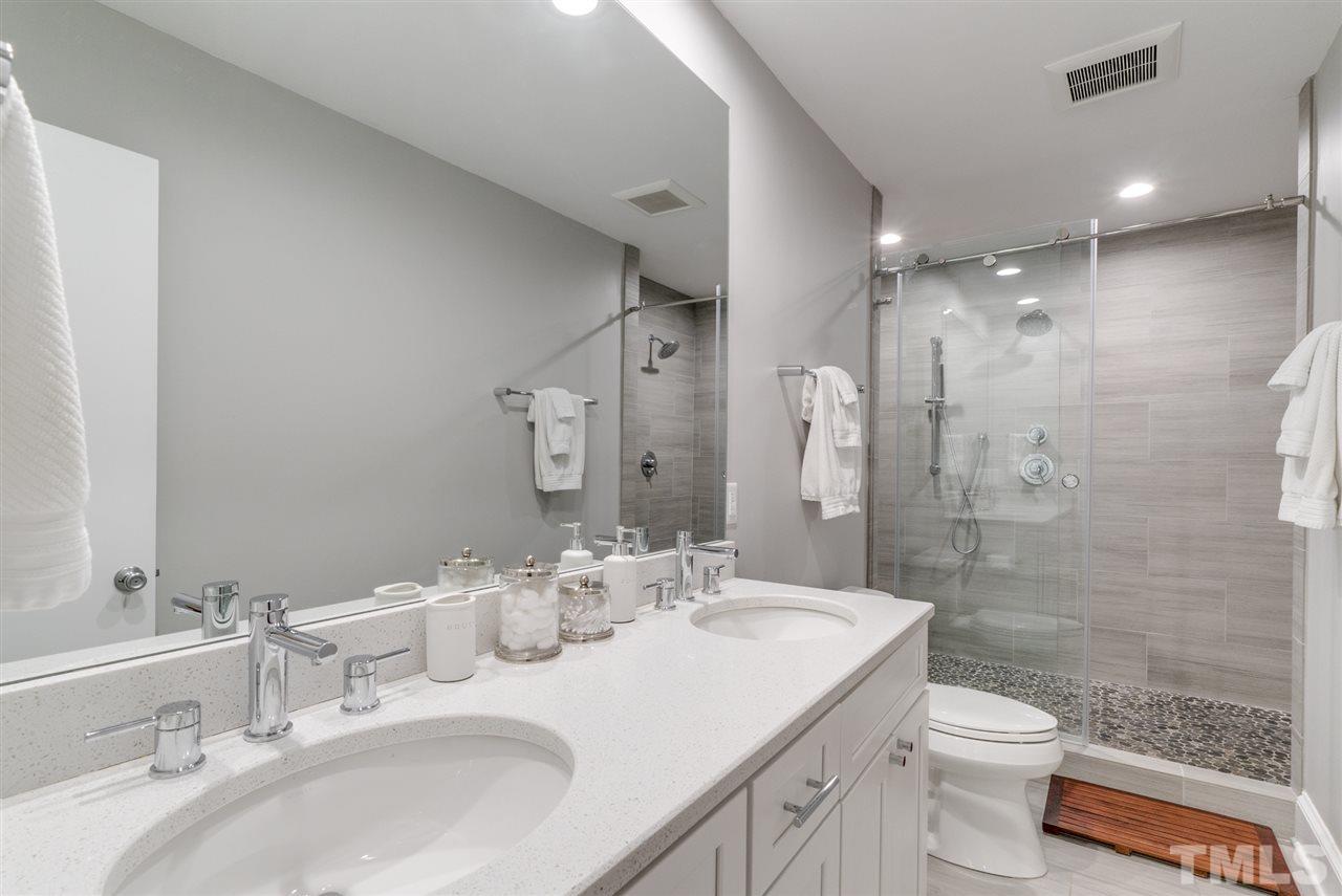 3105 Chancery Place Raleigh, NC 27607 - Photo 13 of 25 a bathroom with a granite countertop sink a toilet a mirror and shower