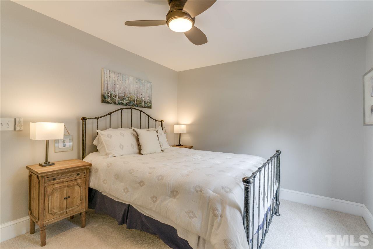 3105 Chancery Place Raleigh, NC 27607 - Photo 17 of 25 a bedroom with a bed and a chandelier