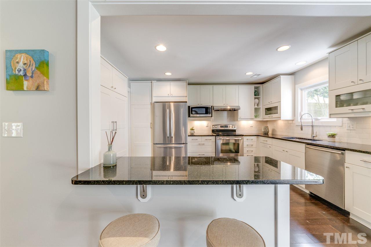 3105 Chancery Place Raleigh, NC 27607 - Photo 7 of 25 a kitchen with stainless steel appliances granite countertop a sink stove and refrigerator