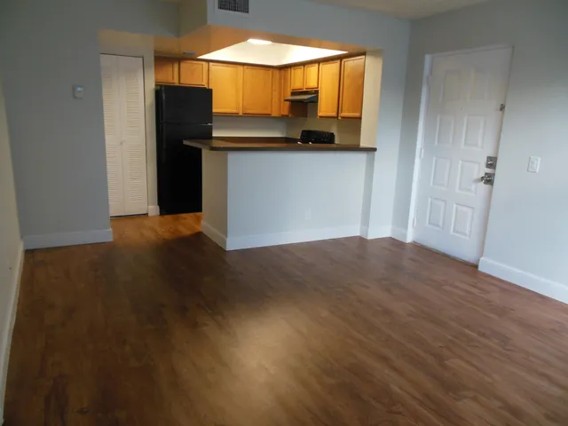 an empty room with wooden floor and a window