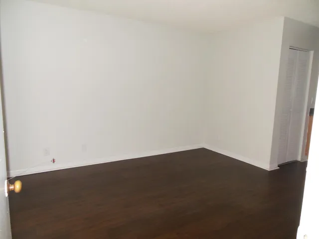 an empty room with wooden floor and a door