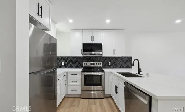 a kitchen with a refrigerator and a stove top oven