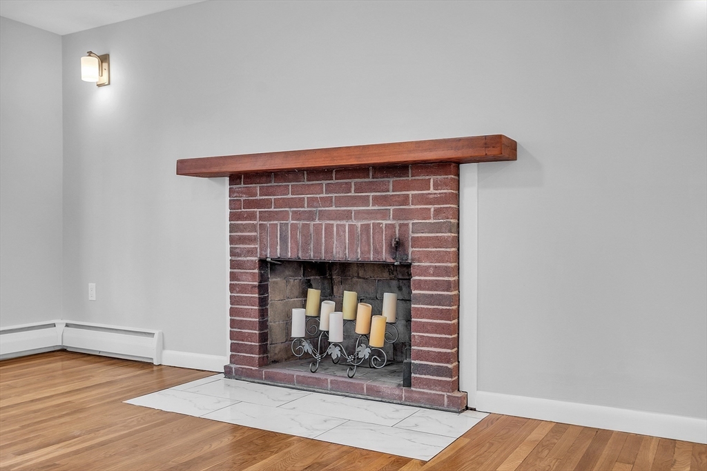 35 Gould Road Andover, MA 01810 - Photo 5 of 37 a view of an empty room with wooden floor and a fireplace