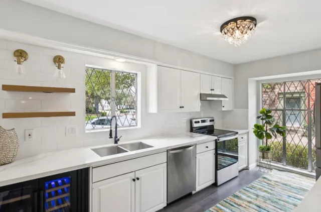 a kitchen with stainless steel appliances a sink a stove and a window