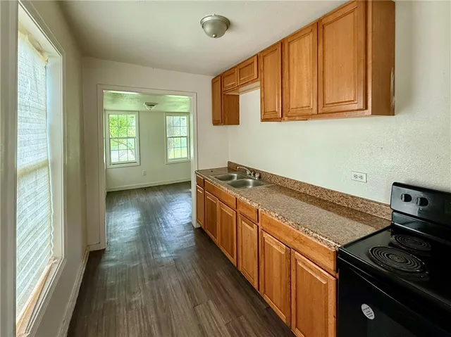 a kitchen with granite countertop a stove and a sink