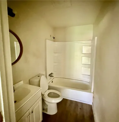 a bathroom with a granite countertop sink toilet and a mirror